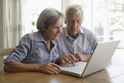 Bild vergrößern: Germany, Bavaria, Senior couple using laptop at home